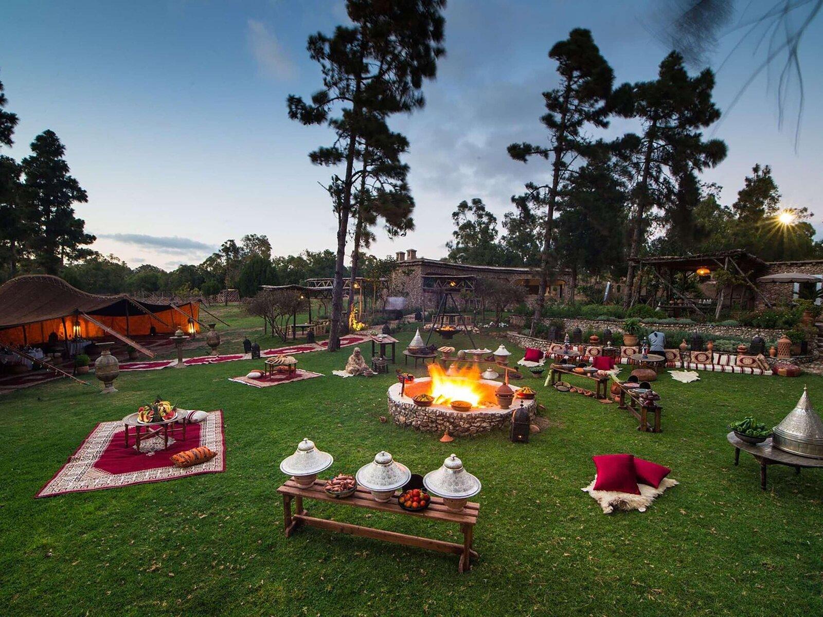 Moroccan night: berber tent, firepit and tagines at dusk